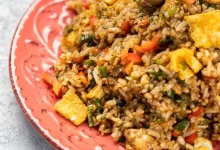 Primer plano de un delicioso arroz cocido con verduras y salsa en un plato sobre la mesa festival 'Montería me sabe a arroz'
